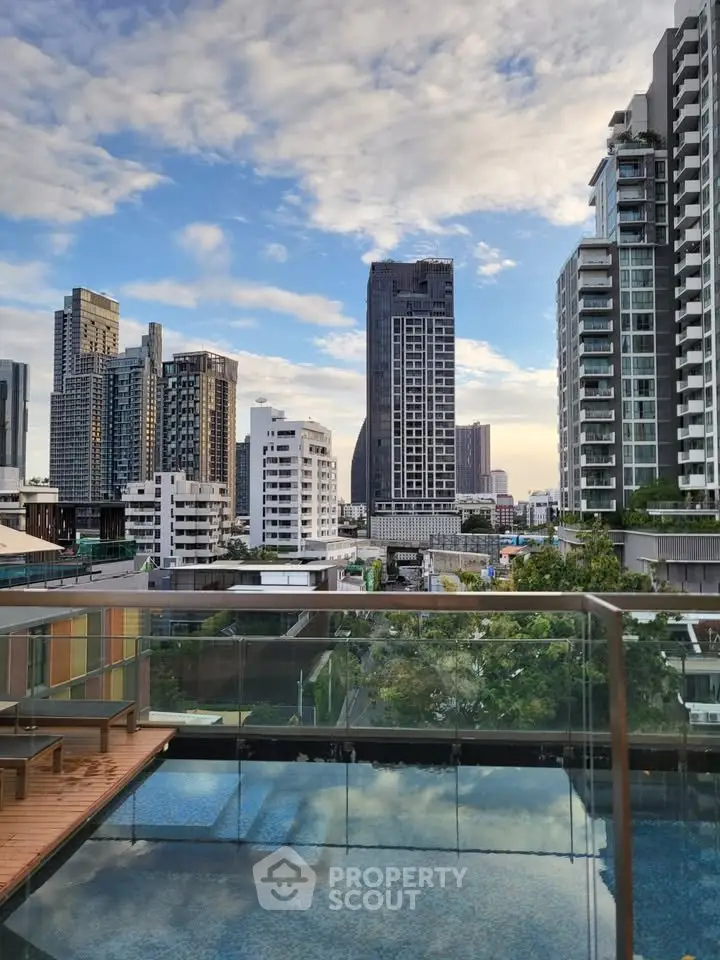 Stunning cityscape view from a modern balcony overlooking skyscrapers and a serene pool.