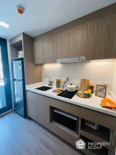 Modern kitchen with sleek cabinetry and built-in appliances in urban apartment