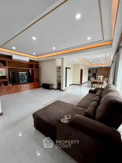 Spacious modern living room with elegant ceiling design and large sectional sofa.