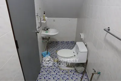 Compact bathroom with modern fixtures and unique tile flooring.