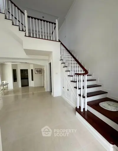Elegant staircase in a spacious home with polished wooden steps and bright interiors.