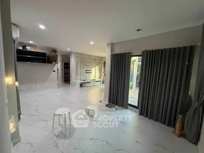 Spacious modern living room with marble flooring and large windows for natural light.