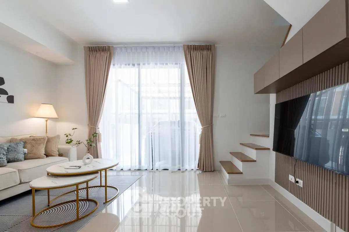 Modern living room with elegant decor, large windows, and stylish furniture in a contemporary home.