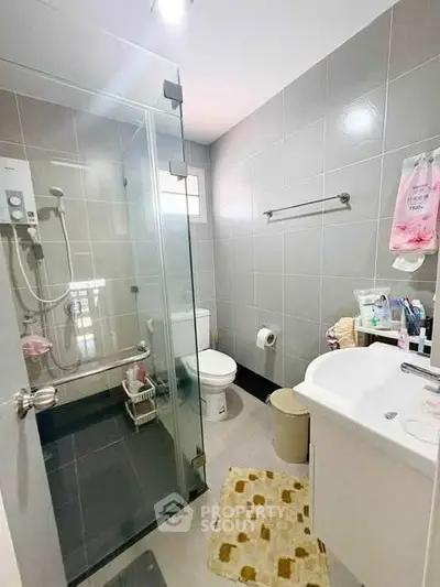 Modern bathroom with glass shower and sleek fixtures in a contemporary home.