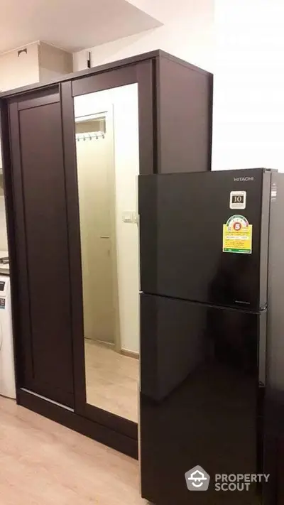 Modern kitchen with sleek black fridge and mirrored cabinet