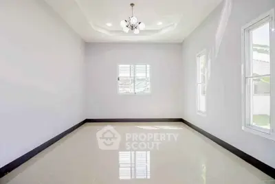 Spacious empty room with glossy tiled floor and modern chandelier
