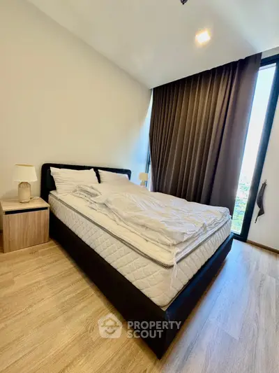 Modern bedroom with large window and elegant curtains in a stylish apartment