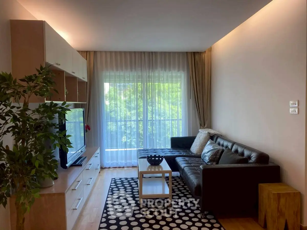 Modern living room with stylish furniture and large window offering natural light and greenery view.