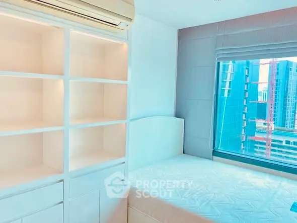 Modern bedroom with built-in shelves and city view window