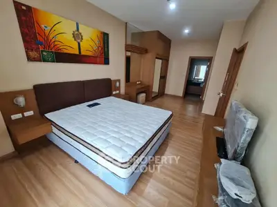 Spacious bedroom with modern decor and wooden flooring in a stylish apartment.