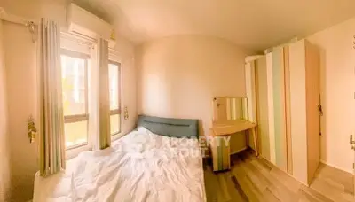 Cozy bedroom with natural light, modern wardrobe, and stylish decor