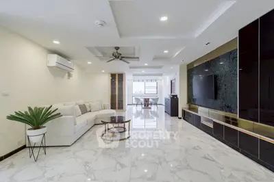 Spacious modern living room with marble flooring and sleek entertainment unit.