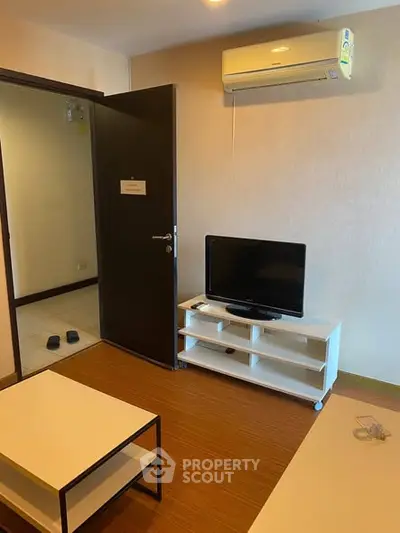 Cozy living room with air conditioning and modern TV setup, perfect for relaxation.