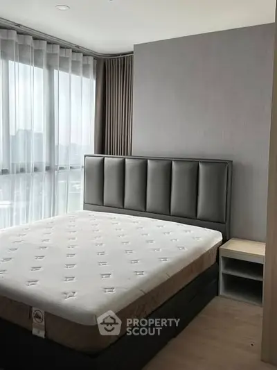 Modern bedroom with large windows and stylish headboard