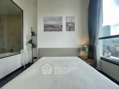 Modern bedroom with large window and city view, featuring stylish decor and comfortable bed.