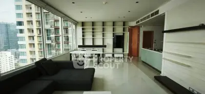 Spacious modern living room with large windows and city view in high-rise apartment.