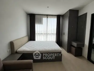 Modern bedroom with minimalist design, featuring a large window and stylish furniture.