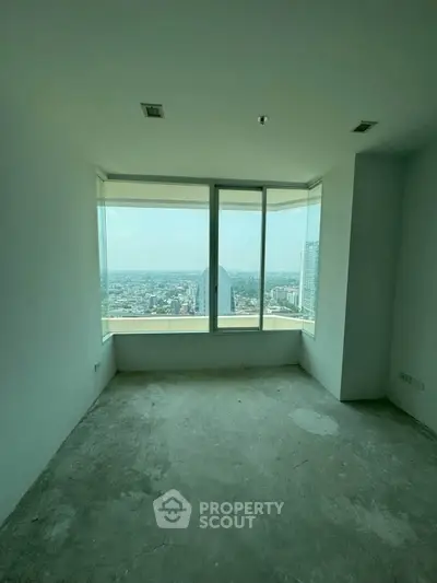 Spacious room with large windows offering stunning cityscape views, perfect for modern living.