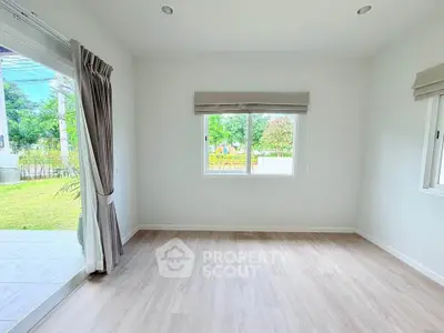 Bright and airy empty room with large windows and garden view, perfect for customization.