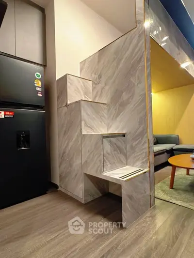 Modern apartment interior with stylish marble staircase and cozy living area.