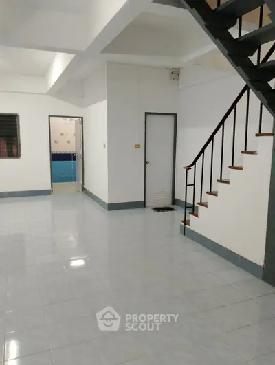 Spacious interior with staircase and tiled flooring, ideal for customization.