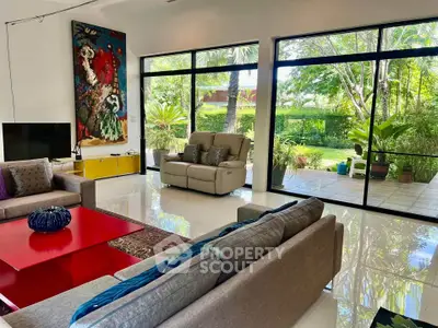 Spacious living room with modern decor and large windows overlooking lush garden.