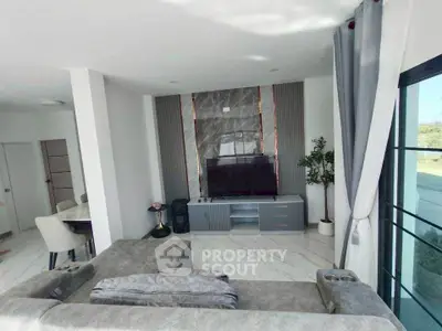 Modern living room with sleek decor and large window offering natural light.