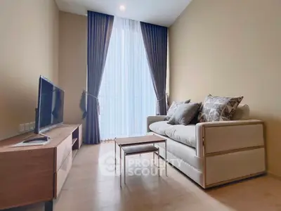 Cozy living room with modern sofa and flat-screen TV, perfect for relaxation.