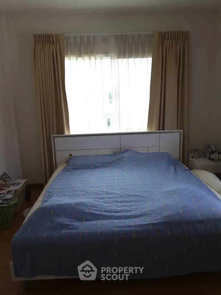 Cozy bedroom with natural light and modern furnishings, perfect for relaxation.