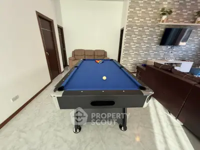 Spacious living room with pool table and modern decor