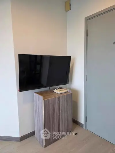 Modern apartment corner with wall-mounted TV and sleek cabinet