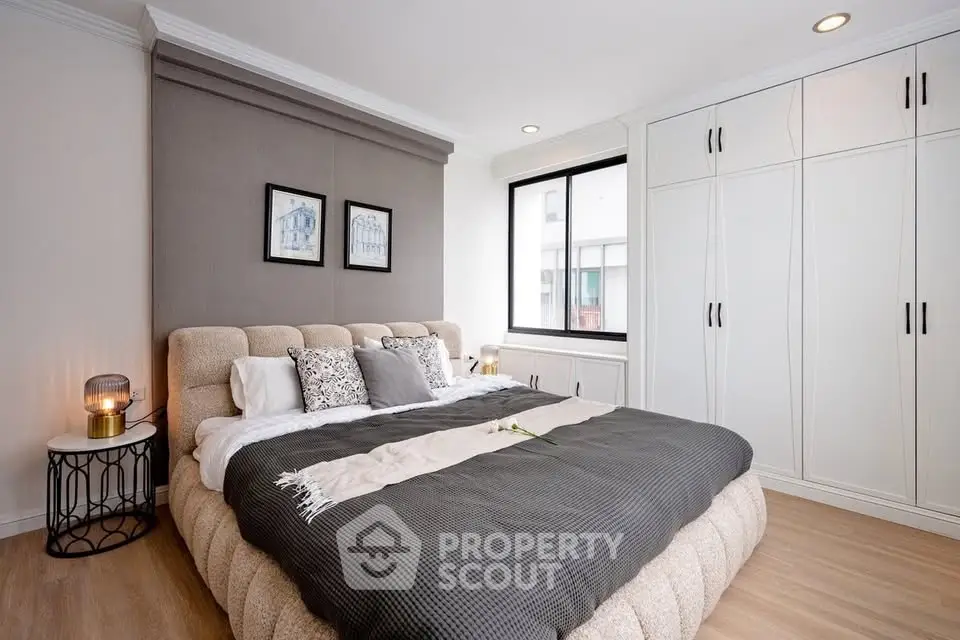 Luxurious bedroom with plush bed, elegant decor, and ample closet space in modern apartment.