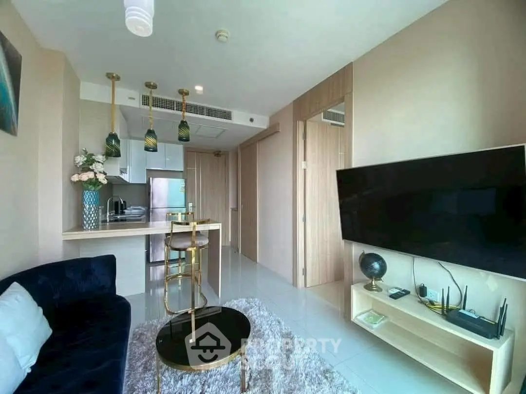 Modern living room with open kitchen, stylish decor, and cozy seating area.