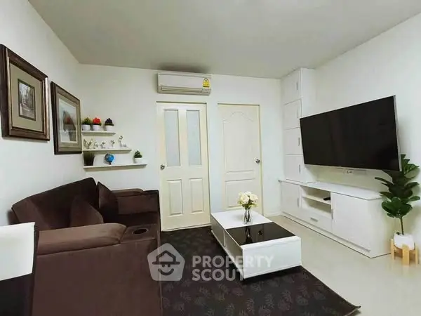 Modern living room with sleek furniture and large TV, perfect for relaxation and entertainment.