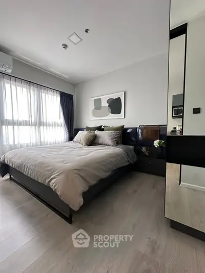 Modern bedroom with stylish decor and large window for natural light