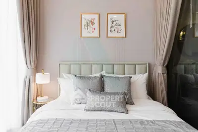 Elegant bedroom with stylish decor and soft lighting, featuring a cozy bed and framed artwork.