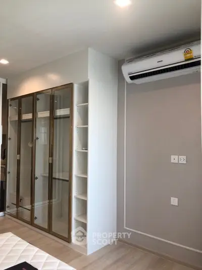 Modern bedroom with built-in wardrobe and air conditioning unit