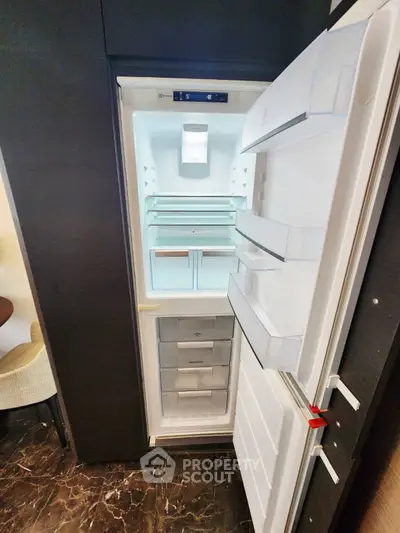 Modern built-in refrigerator in sleek kitchen setting with marble flooring