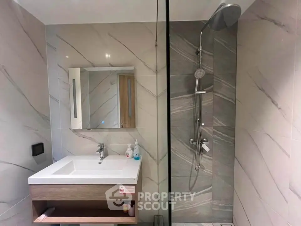 Modern bathroom with sleek shower and stylish vanity in contemporary home.