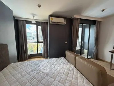 Modern bedroom with city view and balcony access in high-rise apartment