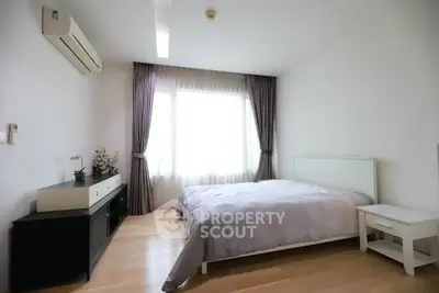 Spacious bedroom with natural light and modern decor in a stylish apartment.