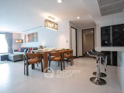 Spacious modern living and dining area with stylish furniture and elegant lighting in a contemporary apartment.