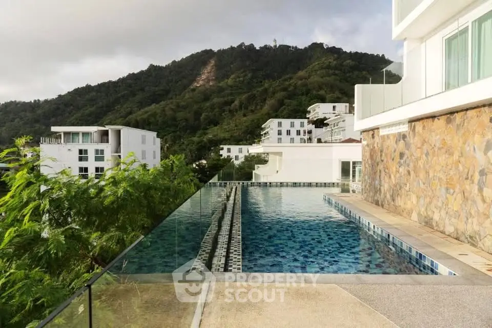 Luxurious infinity pool with stunning mountain views in a modern residential complex.