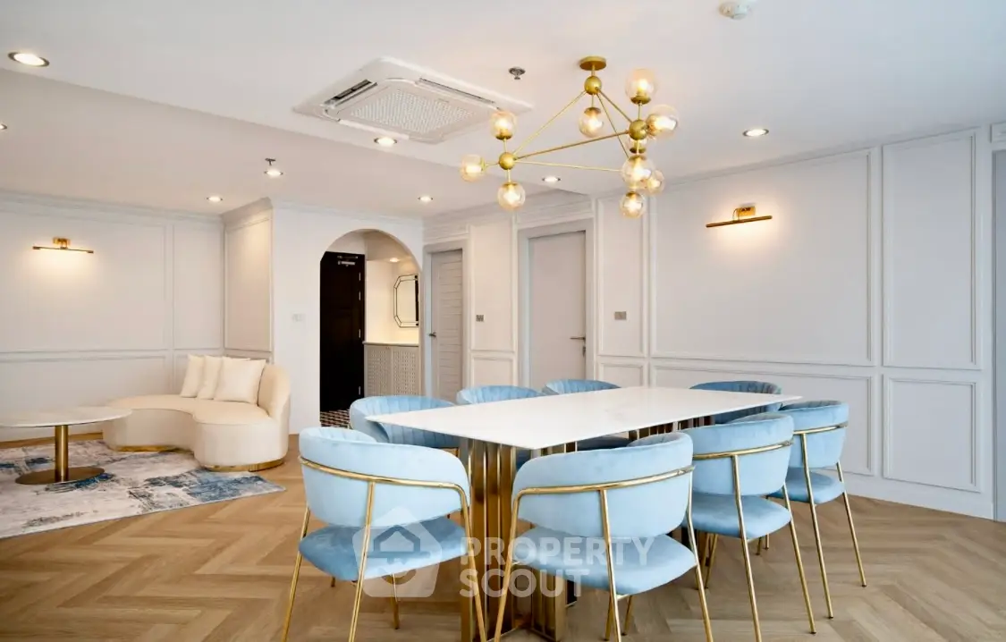 Elegant dining room with modern chandelier and stylish blue chairs