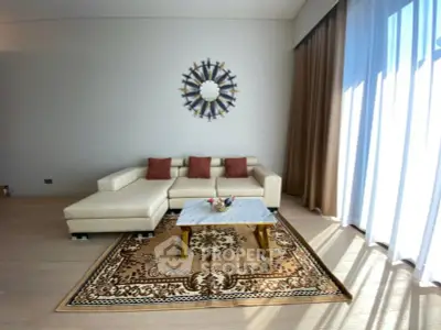 Elegant living room with modern beige sofa, stylish decor, and large window for natural light.