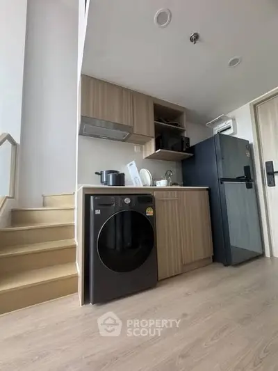 Modern kitchen with washing machine and fridge in stylish apartment