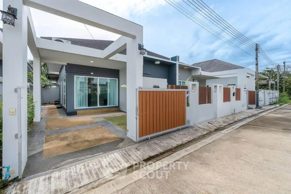 Modern single-story house with sleek design and spacious driveway in a serene neighborhood.