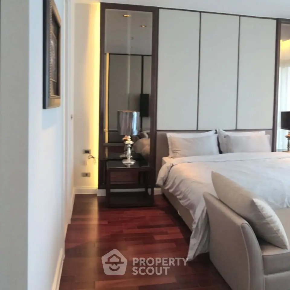 Luxurious bedroom with elegant decor and hardwood flooring in a modern apartment.