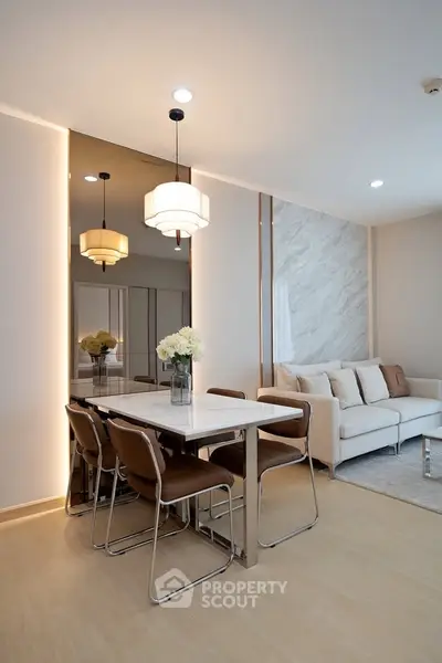 Modern living room with elegant dining area and stylish lighting fixtures.