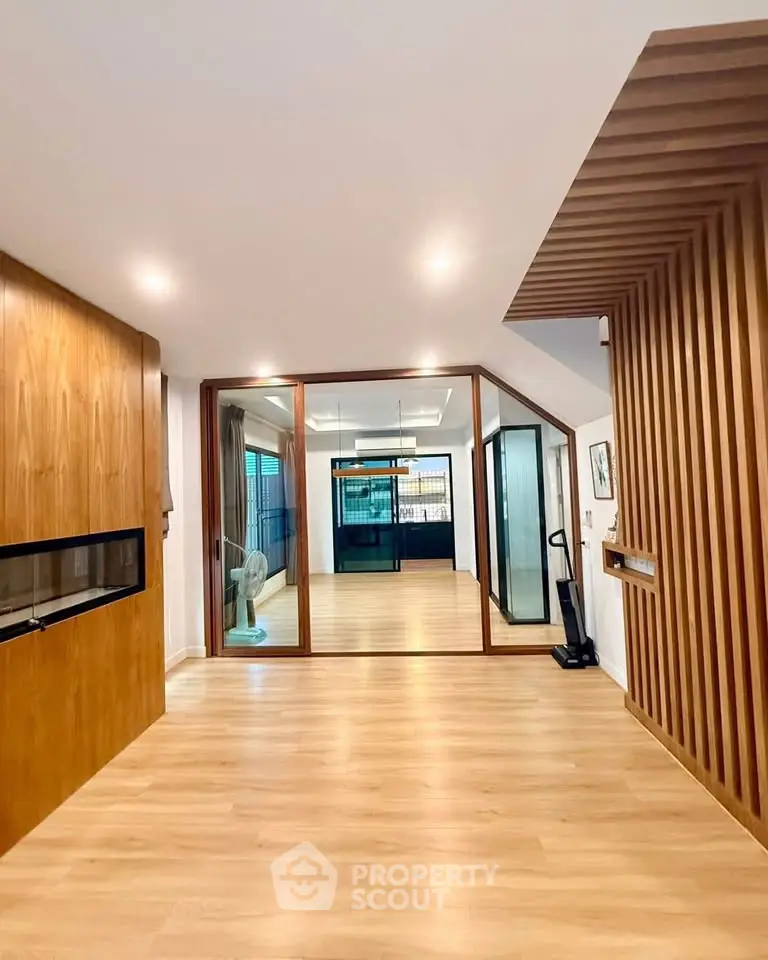 Spacious modern living room with wooden accents and large glass doors